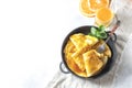 Crepes with Orange Sauce in a cast iron pan. Traditional French crepe Suzette with orange sauce. Royalty Free Stock Photo