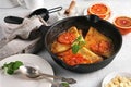 Crepes with Orange Sauce in a cast iron pan. Traditional French crepe Suzette with orange sauce on light table Royalty Free Stock Photo