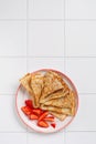 Crepes pancakes with cream cheese and fresh strawberry in beautiful white ceramic plate. Space for text or recipe. Top view Royalty Free Stock Photo