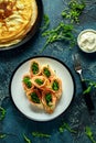 Crepes pancakes rolls with smoked salmon stuffed with wild rocket salad filling served on plate with fresh creme Royalty Free Stock Photo