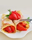 Crepes with strawberries sprinkled with powered sugar Royalty Free Stock Photo