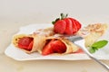 Crepes with strawberries sprinkled with powered sugar Royalty Free Stock Photo