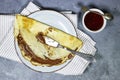 Crepes stuffed with chocolate spread on blue plate with fig jam bowl. Thin pancakes, blini. Sweet dessert Royalty Free Stock Photo