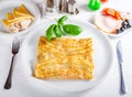 Crepes stuffed with mushrooms, ham, chicken and cheese on white plate Royalty Free Stock Photo