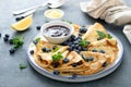 Crepes, thin pancakes with blueberry jam and fresh berries with lemon zest Royalty Free Stock Photo