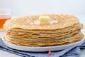 Crepes, thin pancakes with honey and butter on a white plate. Close up.