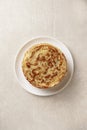 Crepes, thin pancakes with honey on a white plate. Marble background.