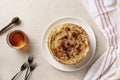 Crepes, thin pancakes with honey on a white plate. Marble background.