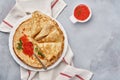 Crepes, thin pancakes, Russian pancakes with red caviar on gray plate. Marble background. Copy space. Top view