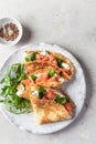 Crepes or thin pancakes with smoked salmon, soft cheese and spinach on a plate close up top view. Pancake day Royalty Free Stock Photo