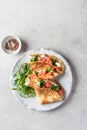 Crepes or thin pancakes with smoked salmon, soft cheese and spinach on a plate top view isolated on gray textured Royalty Free Stock Photo