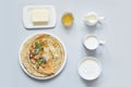 Crepes, thin pancakes on white plate. Pastel blue background. Top view. Set