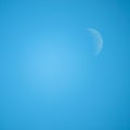 Crescent / half moon in the middle of the day with blue sky in t