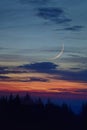 Crescent moon on the night sky seen trough clouds Royalty Free Stock Photo