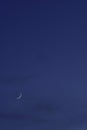 Crescent moon on the night sky seen trough clouds Royalty Free Stock Photo