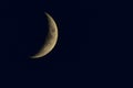 Crescent moon on the night sky seen trough clouds Royalty Free Stock Photo