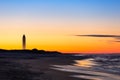 Crescent moon rising just before sunrise next to a tall tower on the beach. Jones Beach State Park