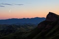 crescent moon between two hill peaks Royalty Free Stock Photo