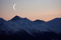 crescent moon between two hill peaks Royalty Free Stock Photo