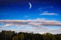 Crescent in the night sky, clouds and stars