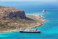 Crete coast, Balos bay, Greece. The ship is going on the marvelous turquoise sea. Popular touristic resort. Summer landscape. Royalty Free Stock Photo