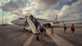 People board the plane on the tarmac