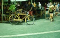 Crete Greece : A retro yellow bicycle with a wifi board in front and a plant in the back in the busy city of