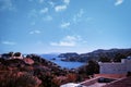 Crete Greece: A view near stalida beach of blue mediterranean sea against rocky mountain. Crete seascape against dramatic clouds