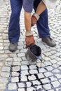 Crew member pouring molten pitch from a tar bucket