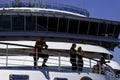 Crew members working onboard of a notorious Cruise ship company relaxing on the open decks while the vessel is docking the