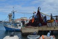 The crew of a purse seiner collects its nets in Olhao fishing harbour, Algarve, Southern Portugal