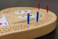 Cribbage card game and board up close looking at the blue and red pegs