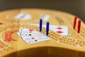 Cribbage card game and board up close looking at the blue and red pegs