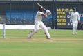 Cricket batsman playing shot and a fielder.