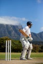 Cricket player practicing against blue sky Royalty Free Stock Photo