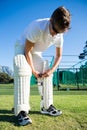 Cricket player wearing kneepad while standing on grassy field Royalty Free Stock Photo
