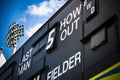 Cricket scoreboard and floodlight at cricket ground in summer