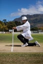 Cricket umpire putting bails on stumps at field