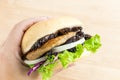 Crickets insect for eating as food items in bread burger with vegetable made of fried insect meat in the woman hands, it is good Royalty Free Stock Photo