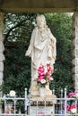 Statue of Jesus Christ at local cemetery with candles and flowers