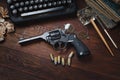 Crime fiction story - old retro vintage typewriter and revolver gun with ammunitions, books, blank paper, old ink pen Royalty Free Stock Photo