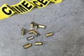 Crime scene concept with a gun, crime scene tape and bullet casings
