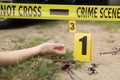 Crime scene with dead woman's body, marker, bloody knife and yellow tape outdoors, closeup Royalty Free Stock Photo