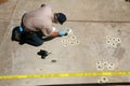 A crime scene detective investigates and gathers evidence at a drive by shooting crime scene