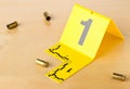 Crime scene investigation CSI evidence marker with empty, fired 9mm bullet casings on wood floor background at crime scene -