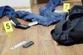 Crime scene investigation - numbering of evidences after the murdering in apartment. Brass knuckle, wallet and clothes with