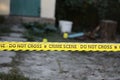 Crime scene tape for covering the area cordon. Yellow tape with blurred forensic law enforcement background in cinematic tone Royalty Free Stock Photo
