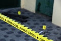 Crime scene tape for covering the area cordon. Yellow tape with blurred forensic law enforcement background in cinematic tone Royalty Free Stock Photo