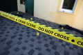 Crime scene tape for covering the area cordon. Yellow tape with blurred forensic law enforcement background in cinematic tone Royalty Free Stock Photo