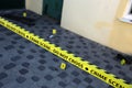 Crime scene tape for covering the area cordon. Yellow tape with blurred forensic law enforcement background in cinematic tone Royalty Free Stock Photo